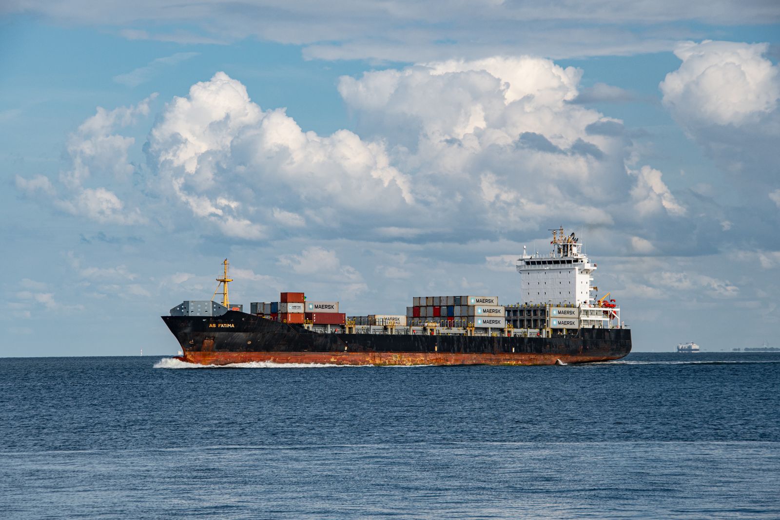 Container ship on calm blue water